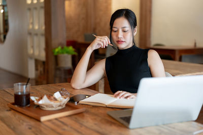 Young woman using laptop at table