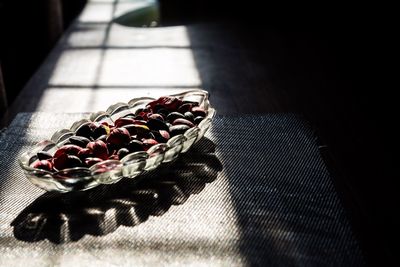 Sunlight falling on nuts in glass bowl at table