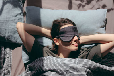 Portrait of young woman sleeping on bed at home