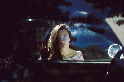 Close-up of young woman in car