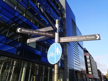 Bristol cycle route signpost  against backdrop of office buildings and blue sky. 