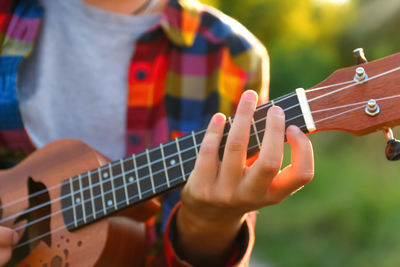 Midsection of man playing guitar