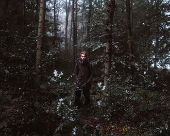 Portrait of man standing at forest