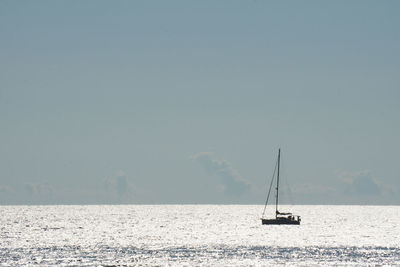 Sailboat sailing on sea against clear sky