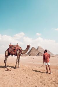 Men standing on desert against sky