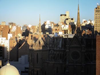 Buildings in city against clear sky