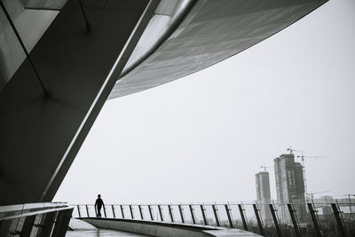 Low angle view of bridge and buildings against clear sky