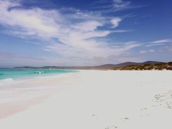 Scenic view of beach against cloudy sky