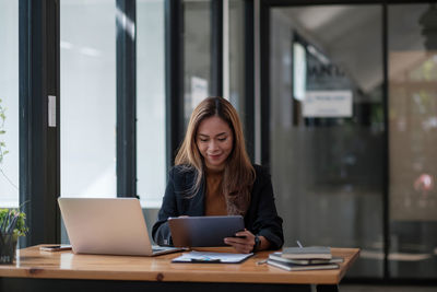 Young businesswoman using laptop on table