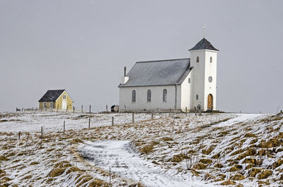 The church and library of flatey island during a rare occasion with both snowfall and sunshine