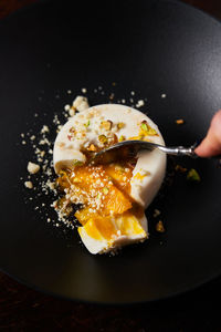 Anonymous woman eating stylish dessert with spoon