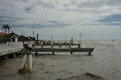 Pier on beach against sky