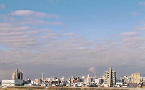 View of cityscape against cloudy sky