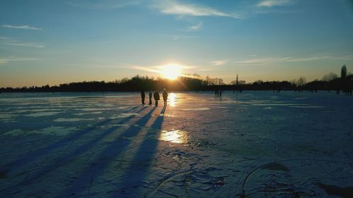 Scenic view of frozen lake against sky during sunset