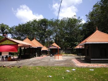 Trees by built structure against sky