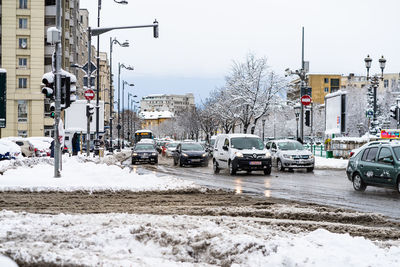 Cars on street by buildings in city