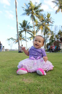 Cute baby girl sitting on field