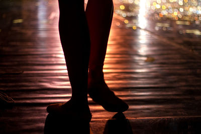 Low section of woman walking on road