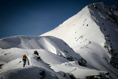 Rear view of man skiing on snow covered landscape