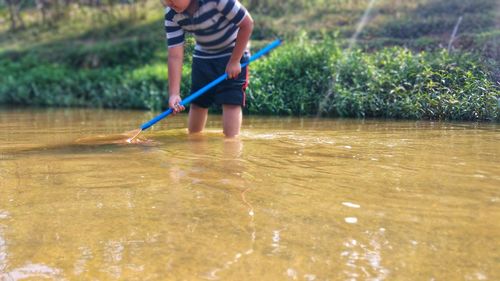 Low section of man standing in water