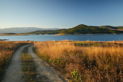 Scenic view of road by land against sky