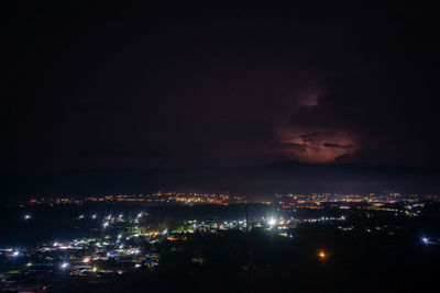 High angle view of illuminated buildings in city against sky at night