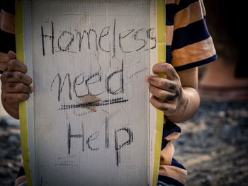 Close-up of beggar holding text