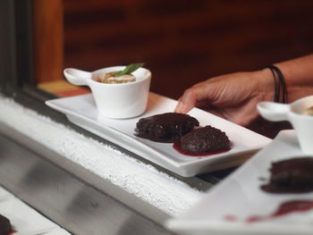 Close-up of hand holding ice cream on table