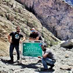 Friends standing on rock against mountain