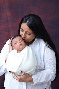 Portrait of young woman lying on bed at home
