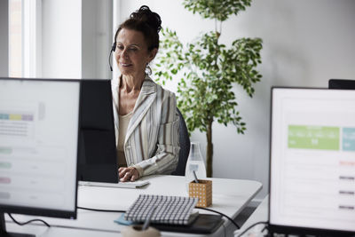 Smiling mature woman working in call center