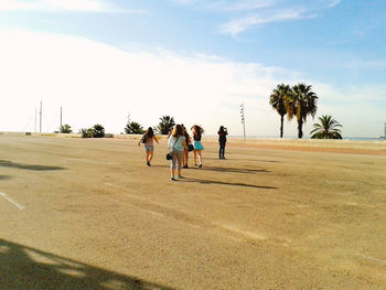 Children standing on landscape against sky