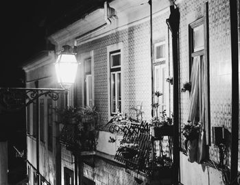 Illuminated street light by building in city at night