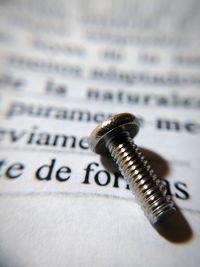 Close-up of screw on paper