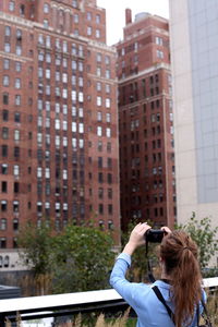 Man photographing with mobile phone in city