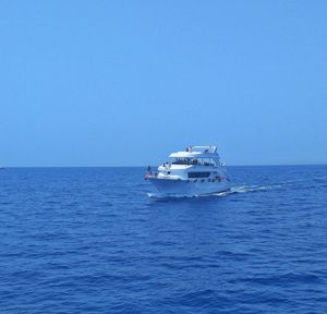 Ship sailing in sea against clear sky