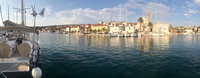 Sailboats in river against buildings in city