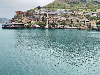 Scenic view of sea by buildings against sky