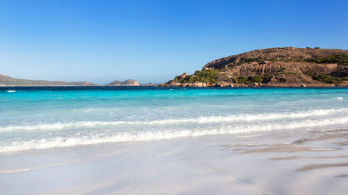 Scenic view of beach against clear blue sky