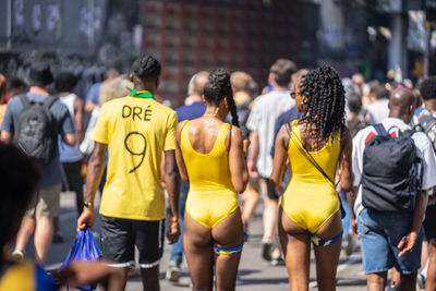 Rear view of people walking on street in city