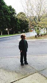 Full length of boy standing on sidewalk