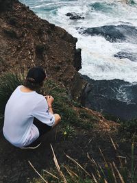 Rear view of man looking at sea from cliff