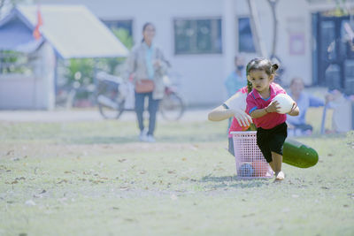 Portrait of boy playing with ball on field