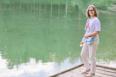 A girl on the shore of the lake with fish on a summer day