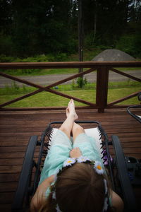 Girl sitting on chair at porch