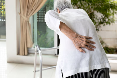 Rear view of senior woman touching back due to ache