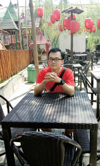 Young man sitting on table in restaurant