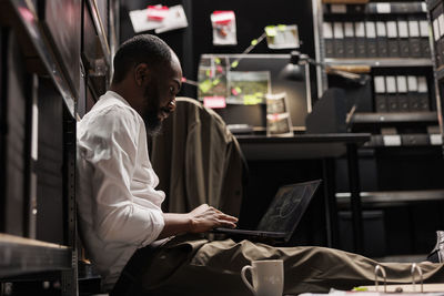 Young woman using laptop at cafe