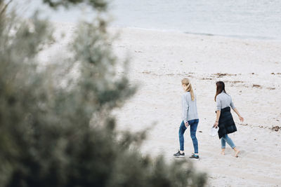 Rear view of women walking on beach