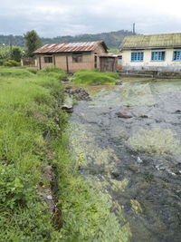 Houses by river against sky